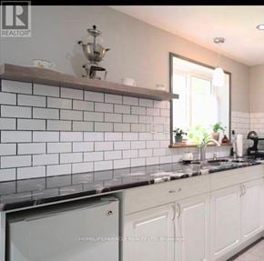 Cambridge apartment for rent - A kitchen with white cabinets and a black countertop.