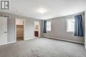 Welland (Lincoln/Crowland) apartment for rent - A spacious room with a carpeted floor and a window with blue curtains.