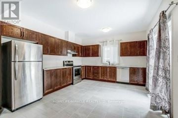 Welland (Lincoln/Crowland) apartment for rent - A kitchen with wooden cabinets and a stainless steel refrigerator.
