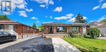 Mississauga (Malton) apartment for rent - A residential area with houses and a car parked in front.