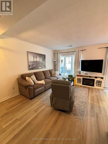 Mississauga (Hurontario) townhouse for rent - A living room with a brown couch and a grey coffee table.