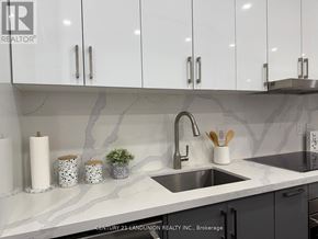 Toronto (Church-Yonge Corridor) condo for rent - A kitchen with a marble backsplash and white cabinets.