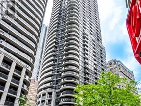 Toronto (Church-Yonge Corridor) condo for rent - A tall building with a red sign on the right side.
