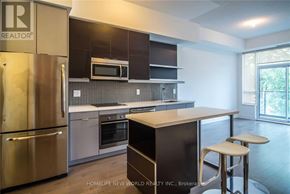 Toronto (Willowdale East) condo for rent - A modern kitchen with stainless steel appliances and a breakfast bar.