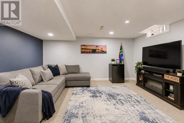 Burlington (Uptown) apartment for rent - A living room with a grey couch and a blue rug.