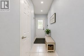 Burlington (Uptown) apartment for rent - A hallway with a white door and a bench with a plant on it.