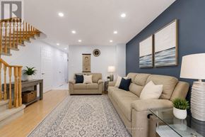 Burlington (Uptown) apartment for rent - A living room with a beige sofa, a glass coffee table, and a staircase with wooden railings.