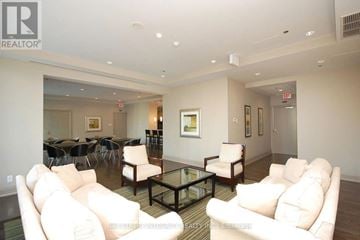 Mississauga (Fairview) condo for rent - A living room with white couches and a glass coffee table.