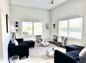 Decatur apartment for rent - A living room with black furniture and a white ceiling fan.