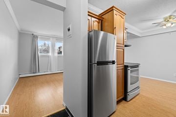 Edmonton apartment for rent - A kitchen with a stainless steel refrigerator and wooden cabinets.