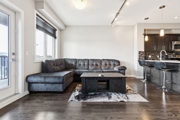 Edmonton apartment for rent - A modern living room with a grey sofa and a black fireplace.