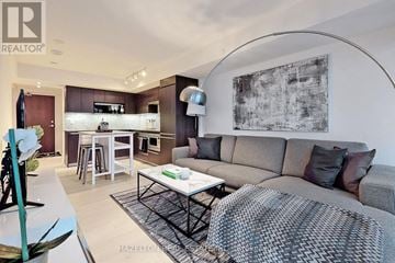 Toronto (Waterfront Communities) condo for rent - A modern living room with a grey sofa and a coffee table.