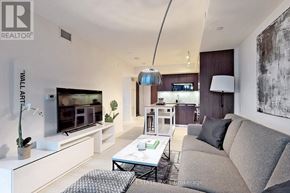 Toronto (Waterfront Communities) condo for rent - A modern living room with a grey sofa and a glass coffee table.