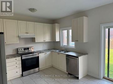 Brock (Beaverton) apartment for rent - A kitchen with white cabinets and a black stove top oven.