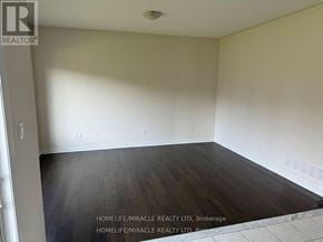 Brock (Beaverton) apartment for rent - A room with wooden flooring and white walls, with text indicating it is a property listing for HomeLife/Miracle Realty LTD in Brokerage.