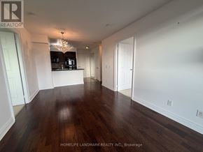 Toronto (Newtonbrook West) condo for rent - A room with wooden floors and white walls, with a chandelier hanging from the ceiling.