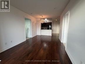 Toronto (Newtonbrook West) condo for rent - A spacious room with wooden floors and a chandelier.