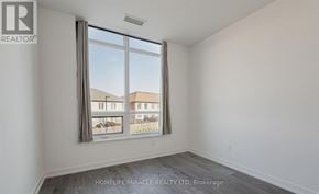 Whitby (Pringle Creek) condo for rent - A room with a large window showing a view of buildings outside.
