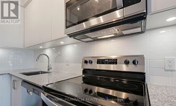 Whitby (Pringle Creek) condo for rent - A modern kitchen with a stainless steel oven and microwave above it.