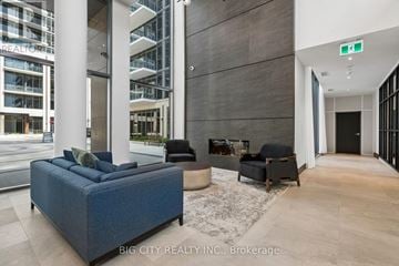 Milton (Tm Timberlea) condo for rent - A living room with a blue couch and a fireplace.