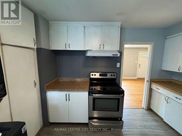 London East (East D) apartment for rent - A kitchen with white cabinets and a black stove top oven.
