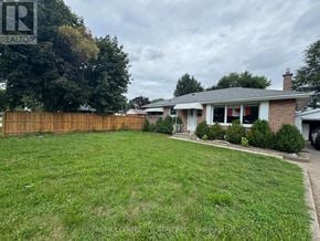 London East (East D) apartment for rent - A backyard with a fence and a house in the background.