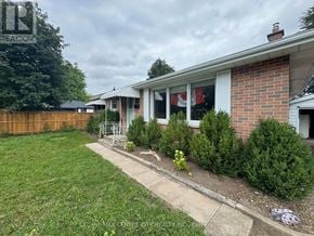 London East (East D) apartment for rent - A house with a lawn and a fence in front of it.