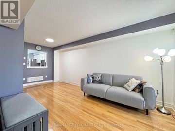 Markham (Cornell) townhouse for rent - A living room with a grey couch and a lamp.