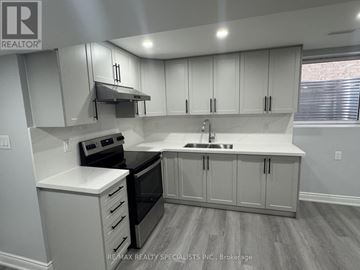 Brampton (Bram East) apartment for rent - A kitchen with white cabinets and a black stove top oven.