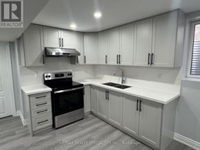 Brampton (Bram East) apartment for rent - A kitchen with white cabinets and a black oven.