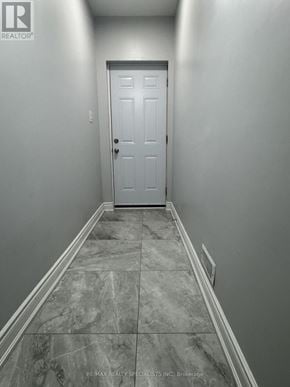 Brampton (Bram East) apartment for rent - A hallway with a marble floor and a white door.