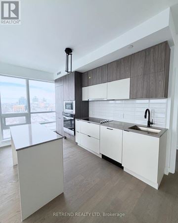 Richmond Hill (South Richvale) condo for rent - A modern kitchen with white cabinets and a large island.