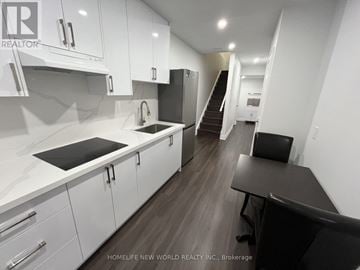 Markham (Cornell) apartment for rent - A modern kitchen with white cabinets and a black countertop.