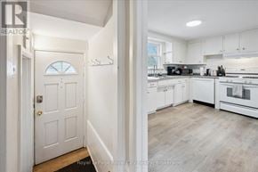 Guelph (St. Patrick's Ward) triplex for rent - A white door is on the left and a kitchen is on the right.