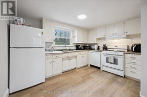 Guelph (St. Patrick's Ward) triplex for rent - A white kitchen with wooden floors and white appliances.