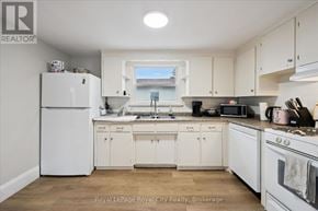 Guelph (St. Patrick's Ward) triplex for rent - A white kitchen with wooden floors and white appliances.