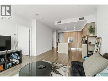 Burnaby apartment for rent - A living room with a glass table and a black couch.
