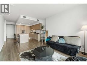 Burnaby apartment for rent - A modern living room with a black and white couch, a coffee table, and a wooden floor.