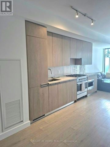 Toronto (Edenbridge-Humber Valley) condo for rent - A modern kitchen with wooden cabinets and stainless steel appliances.