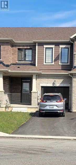 Thorold (Rolling Meadows) townhouse for rent - A silver car is parked in a garage attached to a brick house.