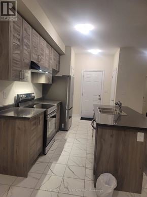 Thorold (Rolling Meadows) townhouse for rent - A kitchen with wooden cabinets and a white door.