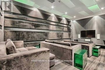 Toronto (Waterfront Communities) condo for rent - A modern living room with a grey couch and green side tables.