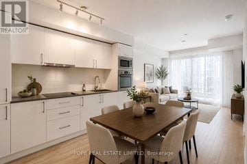 Toronto (Waterfront Communities) condo for rent - A modern kitchen with a dining table and chairs.