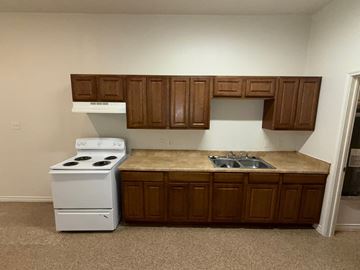 Temple apartment for rent - A white stove and oven in a kitchen with brown cabinets.