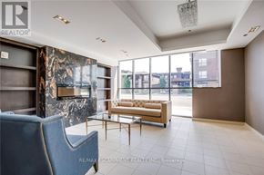 Burlington (Uptown) condo for rent - A living room with a blue chair and a marble fireplace.
