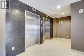 Burlington (Uptown) condo for rent - A hallway with two elevators and a brokerage sign.