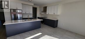 Adjala-Tosorontio (Colgan) apartment for rent - A kitchen with white cabinets and a dark island.
