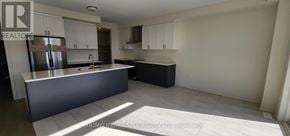 Adjala-Tosorontio (Colgan) apartment for rent - A kitchen with white cabinets and a grey island.
