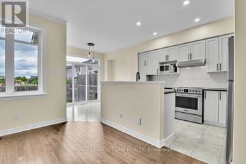 Ottawa townhouse for rent - A kitchen with white cabinets and a stove top oven.