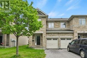 Ottawa townhouse for rent - A large house with a tree in front and a car parked in front.